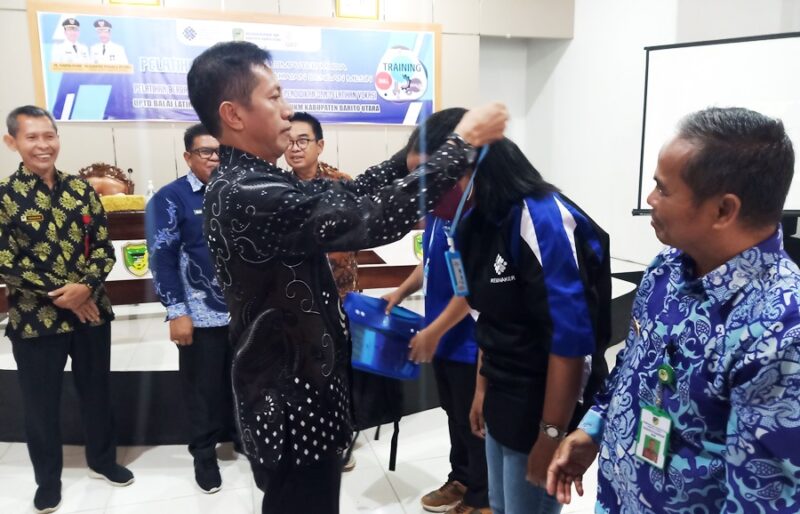 Sekda Barito Utara Drs Muhlis mengalungkan tanda peserta kepada perwakilan peserta pelatihan, Kamis 6 Oktober 2022