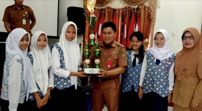 Kepala Dinas Pendidikan Barito Utara Drs H Ardian didampingi Sekdis Pendidikan Sri Hartati menyerahkan piala O2SN kepada pelajar SMPN, Selasa 1 November 2022 (Tegak Lurus : ist)