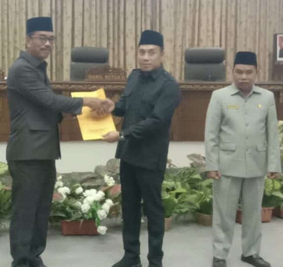 FOTO : Wabup Barito Utara Sugianto Panala Putra menyerahkan jawaban bupati tentang Raperda Pengakuan dan perlindungan Masyarakat Hukum Adat kepada Wakil Ketua I DPRD Parmana Setiawan didampingi Waket II Sastra Jaya, Jumat 10 Februari 2023.(Tegak Lurus)