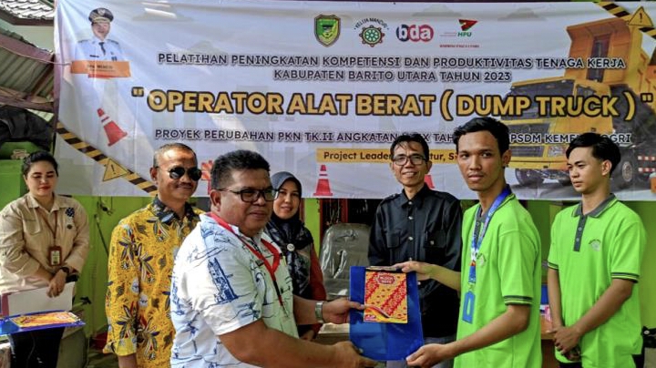 Kadisnakertranskop-UKM Barito Utara, M Mastur menyerahkan tanda peserta dan materi pelatihan kepada  peserta pelatihan operator dump truk di Kelua, Kabupaten Tabalong,  Kalsel, Sabtu 11 November 2023.(tegaklurus.net/dor abrams he) 