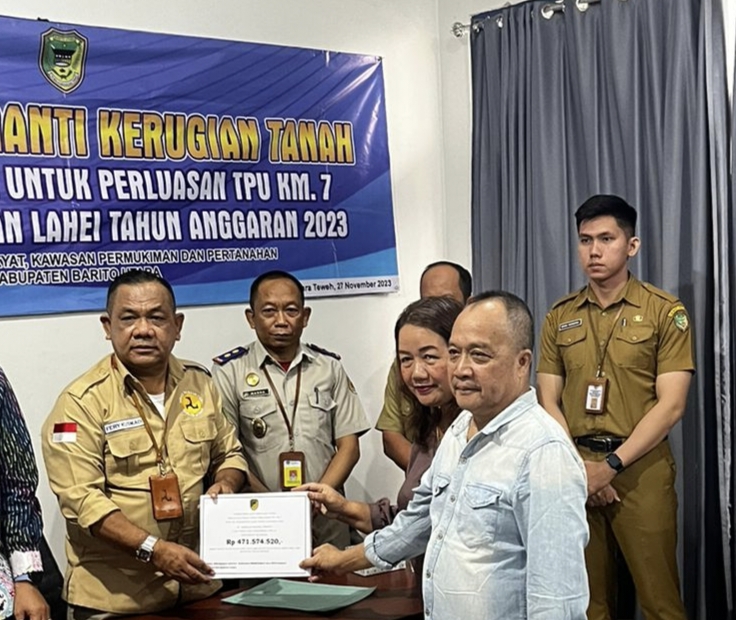Kadis Perkimtan Barito Utara, Fery Kusmiadi, menyerahkan tanda bukti pembayaran lahan seluas 0,9 ha untuk perluasan TPU Km 7 kepada pemilik tanah, Kameloh Endang.(ist)