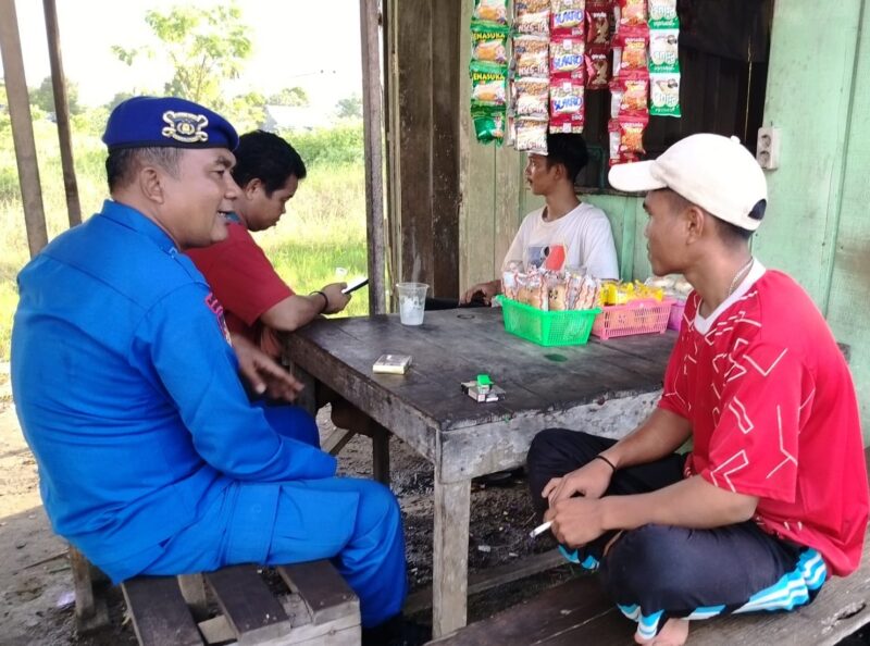 Personel Ditpolairud, Bripka Tri Meri Putra, menyambangi dan menyampaikan pesan-pesan kamtibmas kepada warga yang bekerja sebagai buruh bongkar muat di Desa Kumai Hilir, Kabupaten Kobar, Sabtu, 17 Mei 2025.(Foto : Dok Ditpolairud Polda Kalteng)  