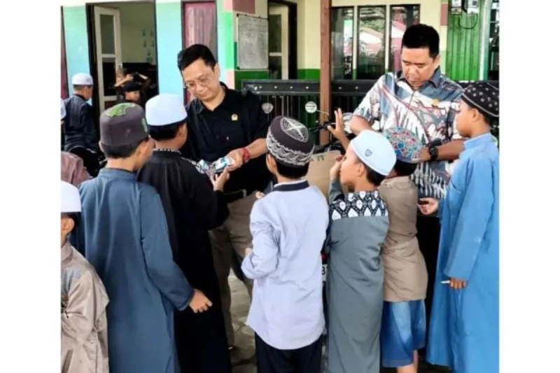 Legislator yang juga Ketua Fraksi PDI Perjuangan DPRD Kabupaten Barito Utara, Taufik Nugraha bersama anggota fraksi Suparjan Efendi, membagikan susu kemasan secara gratis di Desa Kandui, Kecamatan Gunung Timang, Kamis (6/2/2025).(ist : Dok pribadi Taufik Nugraha)