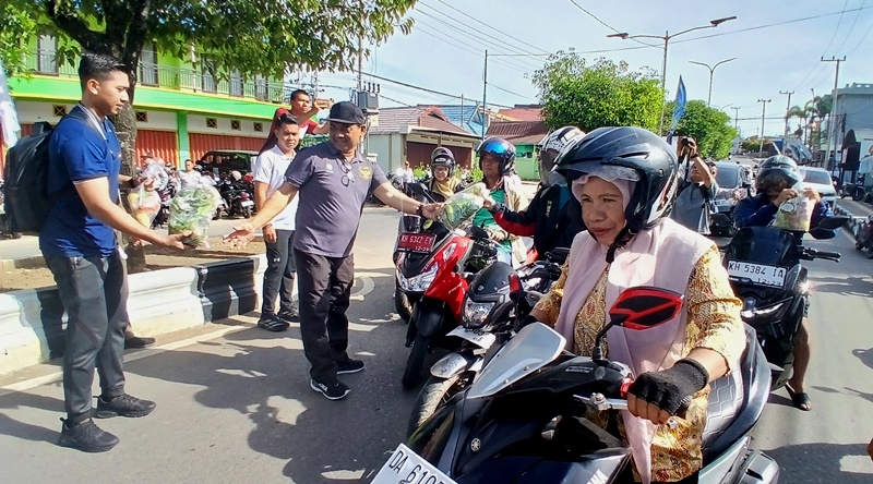 Bupati Barito Utara Shalahuddin didampingi para pejabat lain membagikan bahan pangan kepada para pengendara di depan Dinas KPP, Jalan Ahmad Yani, Muara Teweh, Jumat, 14 November 2025.(abram/tegak lurus.net)