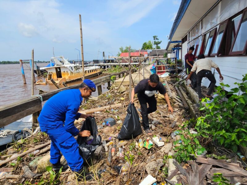 Personel Kp XVIII 2007 DAS Kapuas Ditpolairud Polda Kalteng, mengajak masyarakat Mangkutup membersihkan sampah di pesisir sungai, Kabupaten Kapuas, Kamis, 2 April 2026 siang.(Foto Ditpolairud Polda Kalteng) 